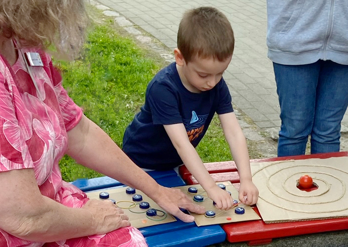 Kind spielt Brettspiel aus Pappe