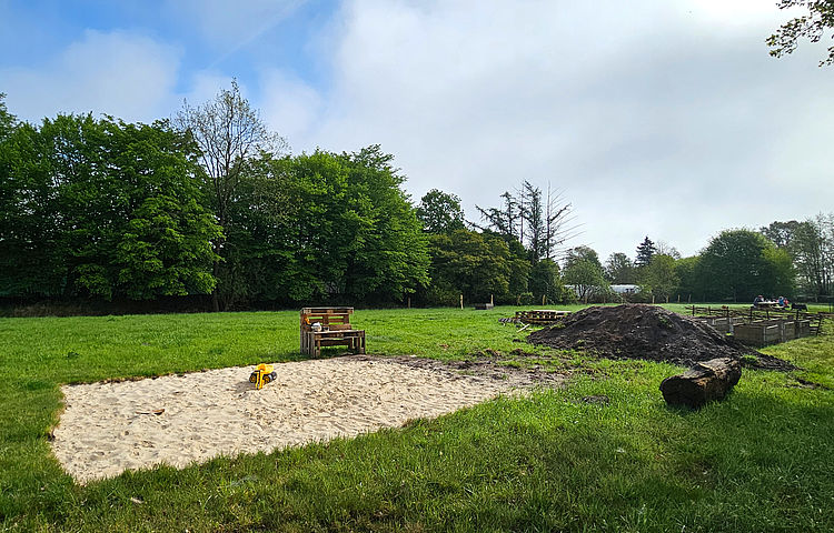 Buddelbereich der Naturkita Appen Buddelbereich mit hellem Sand auf der großen Wiese der Naturkita Appen